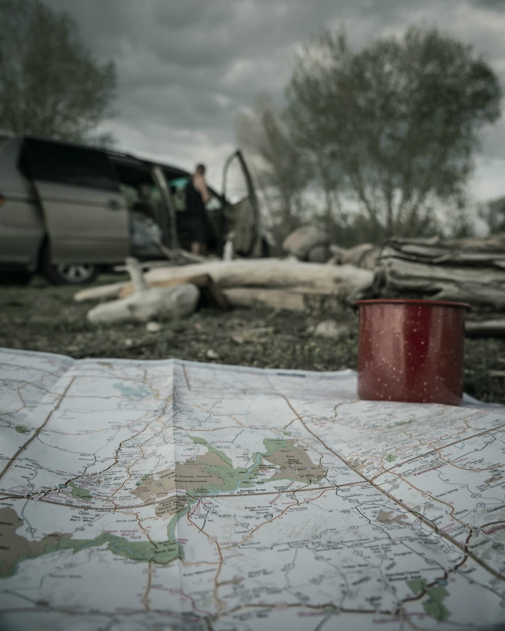 A camp table with a map and an enamel mug.