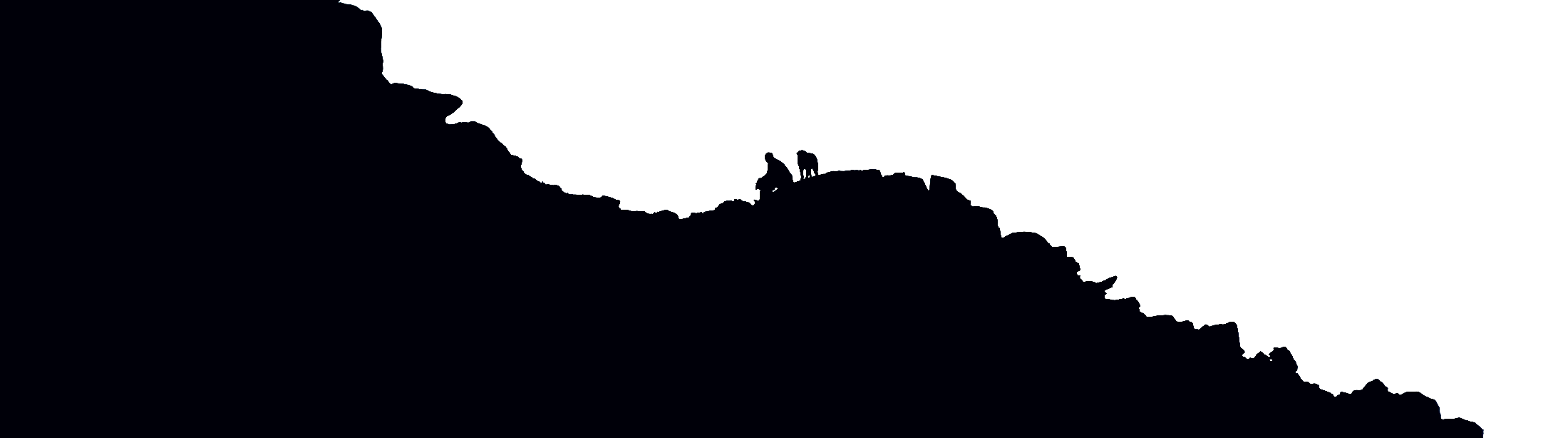 Two climbers standing on a ridge crest, silhouetted against a pale morning sky.