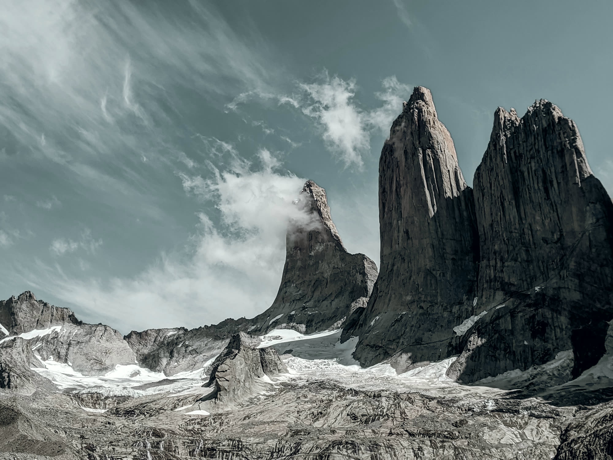 The granite towers of Torres del Paine under a streaked sky.